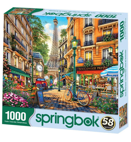 1000-piece Spring Walk, Paris jigsaw puzzle depicting a colorful Parisian street with the Eiffel Tower, a bicycle, and outdoor cafés, available at The Puzzle Center.