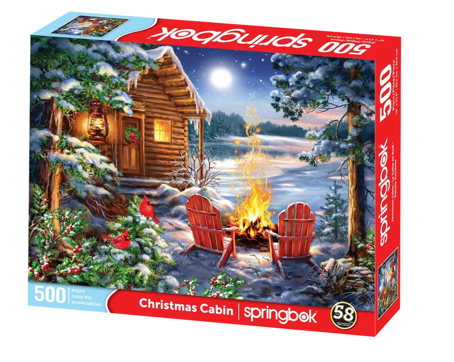 Christmas Cabin 500 piece puzzle by Springbok featuring a cozy cabin with a fire and two chairs by a lake