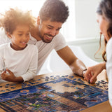 Family putting together the Peter Pan Learning to Fly 500-piece puzzle by Disney and Dowdle