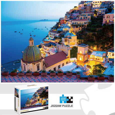 Scenic 1000-piece Positano jigsaw puzzle by The Puzzle Center showcasing the picturesque Italian village at dusk, with illuminated buildings and a serene ocean backdrop.