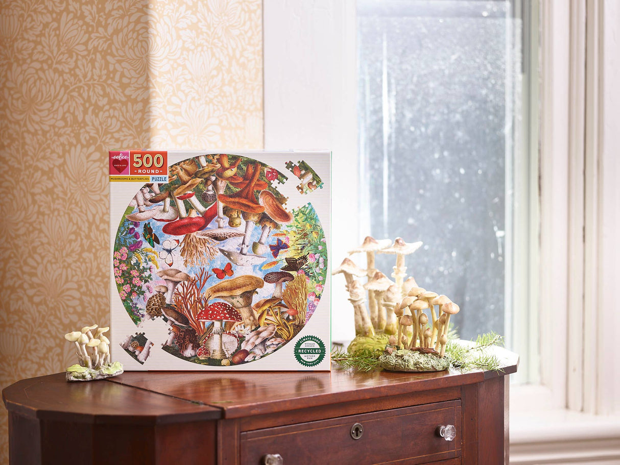 Circular puzzle with mushrooms, butterflies, and vibrant floral details box displayed in a room by eeboo