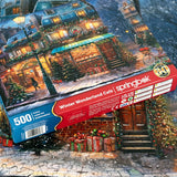 Box and Completed puzzle for the holiday-themed jigsaw puzzle with a cozy cafe, snow-covered streets, and festive decorations by Springbok